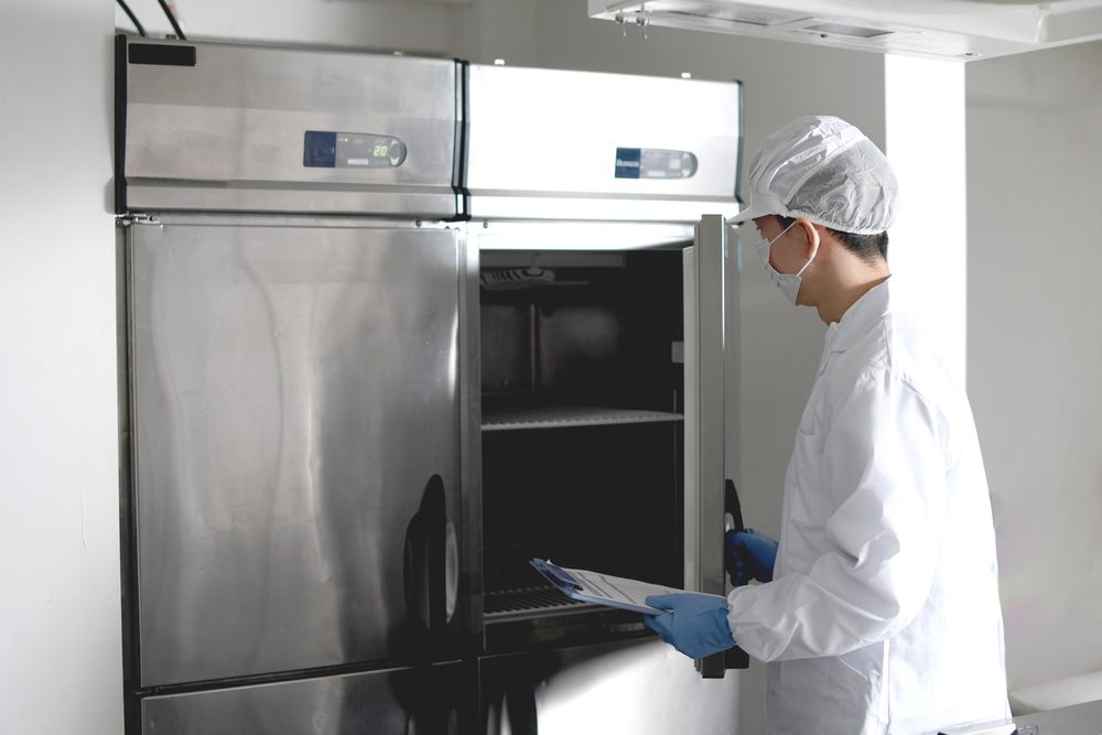 Refrigeration technician inspecting a commercial refrigerator on Long Island